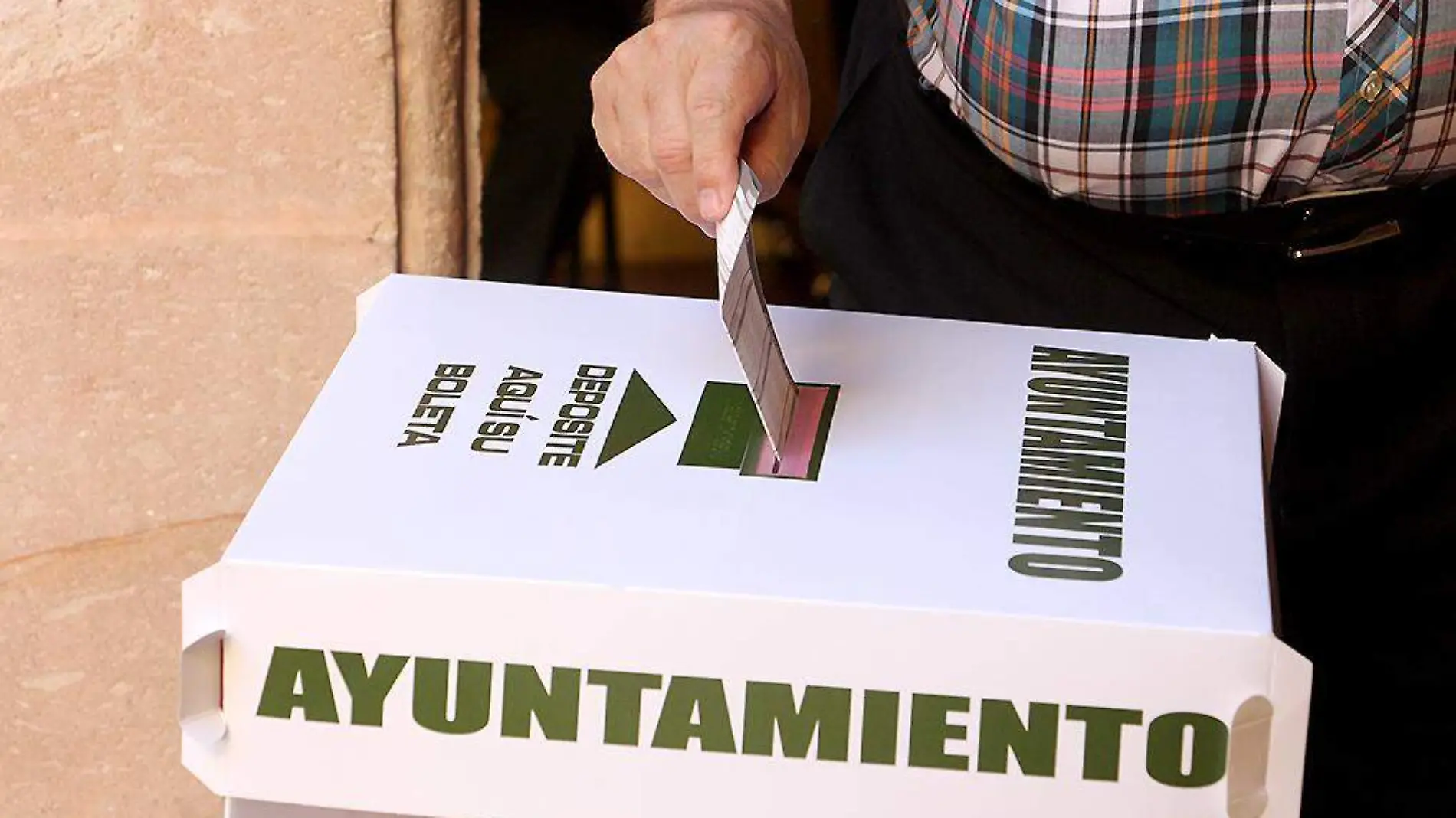 Persona introduciendo su voto a la urna